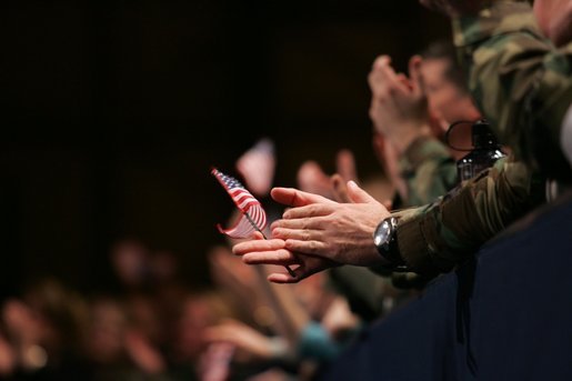 An American flag is highlighted in the crowd Monday, Nov. 14, 2005, as President George W. Bush speaks at Elmendorf Air Force Base in Anchorage on the War on Terror. White House photo by Shealah Craighead