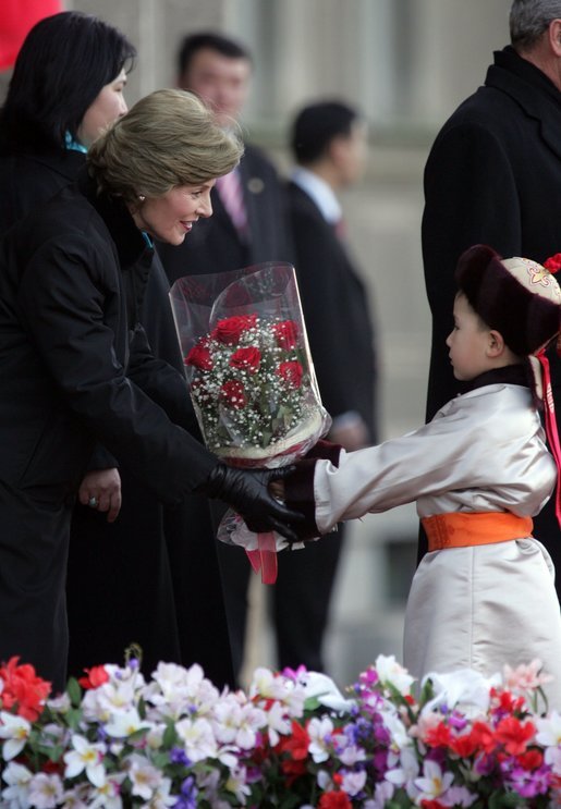 A young boy delivers a bouquet of flowers to Mrs. Bush Monday, Nov. 21, 2005, as she and President Bush joined Mongolia's President and First Lady in ceremonies in Ulaanbaatar welcoming the Bushes to Mongolia. White House photo by Paul Morse