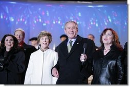 President George W. Bush and Laura Bush join holiday entertainers Thursday evening, Dec. 1, 2005, on stage during the Pageant of Peace and lighting of the National Christmas Tree festivities on the Ellipse in Washington.  White House photo by Paul Morse