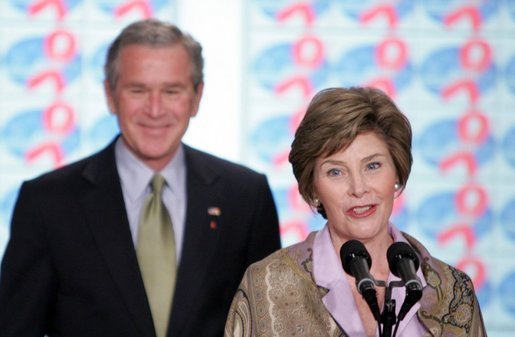 President George W. Bush stands by as he listens to remarks by Mrs. Bush on World AIDS Day before being introduced to the audience at the Dwight D. Eisenhower Executive Office Building Thursday, Dec. 1, 2005. White House photo by Paul Morse