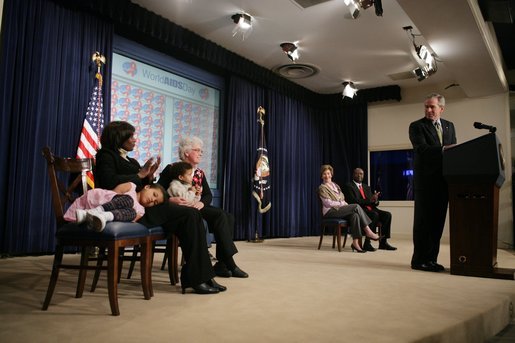 President George W. Bush smiles as he looks back at Thandazile Darby and her two children, 4-year-old Lewis, and 5-year-old Emily. The South African visitors were guests at the Dwight D. Eisenhower Executive Office Building Thursday, Dec. 1, 2005, during the President's remarks on World AIDS Day. White House photo by Paul Morse