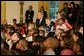 President George W. Bush and Laura Bush sit with children, Monday, Dec. 5, 2005 at the White House, as they watch a dance performance during the White House Children's Holiday Reception in the East Room. White House photo by Kimberlee Hewitt