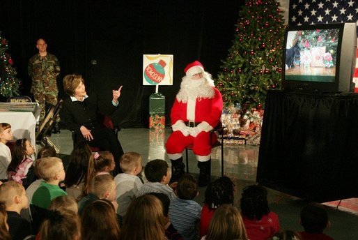 Laura Bush visits with children at the Naval and Marine Corps Reserve Center in Gulfport, Miss., Monday, Dec. 12, 2005, showing them a White House holiday video featuring the Bush's dogs "Barney and "Miss Beazley." White House photo by Shealah Craighead