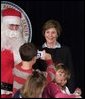 Laura Bush poses for a photo as she visits with children at the Naval and Marine Corps Reserve Center in Gulfport, Miss., Monday, Dec. 12, 2005, where she showed them a White House holiday video, 'A Very Beazley Christmas' featuring the Bush's dogs, Barney and Miss Beazley. White House photo by Shealah Craighead