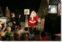 Laura Bush visits with children at the Naval and Marine Corps Reserve Center in Gulfport, Miss., Monday, Dec. 12, 2005, showing them the White House holiday video, 'A Very Beazley Christmas' featuring the Bush's dogs, Barney and Miss Beazley. White House photo by Shealah Craighead