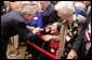 President George W. Bush bends to meet Jean Tessier of Tyson's Corner, Va., during his visit Tuesday, Dec. 13, 2005, to the Medicare Prescription Drug Educational and Enrollment Event at the Greenspring Village Retirement Community in Springfield, Va. White House photo by Paul Morse