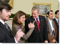 President George W. Bush stands with out-of-country Iraqi voters Thursday in the Oval Office of the White House. The President told the media later, "I was struck by how joyous they were to be able to vote for a government -- a permanent government under a new constitution." White House photo by Paul Morse