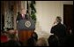 President George W. Bush listens as Terrence Hunt of The Associated Press delivers a question Monday, Dec. 19, 2005, during the President's press conference in the East Room of the White House. In response to Mr. Hunt's question, the President responded, "We're at war, and we must protect America's secrets." White House photo by Paul Morse