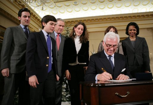 President George W. Bush stands by as John Danilovich signs appointment affidavits after being sworn in Tuesday, Dec. 20, 2005, as the new Chief Executive Officer of the Millennium Challenge Corporation during ceremonies at the U.S. Department of State. Looking on are Secretary of State Condoleezza Rice and members of Mr. Danilovich's family. White House photo by Paul Morse