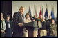 With Mrs. Laura Bush looking on, President George W. Bush addresses military medical caregivers Wednesday, Dec. 21, 2005, before visiting with the wounded at the National Naval Medical Center in Bethesda, Md. The President told the caregivers, ". On behalf of a grateful nation, thanks for doing your duty, thanks for serving, thanks for being an important part of this march for freedom; and thanks, most of all, for bringing comfort and aid and solace to those who have been hurt on the battlefield and their families." White House photo by Paul Morse