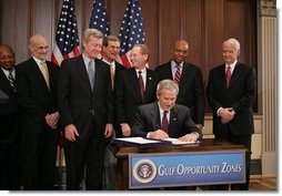 President George W. Bush signs H.R. 4440, the Gulf Opportunity Zone Act of 2005, Wednesday Dec. 21, 2005, as administration officials and legislative members join him for the signing ceremony held in the Dwight D. Eisenhower Executive Office Building in Washington.  White House photo by Paul Morse