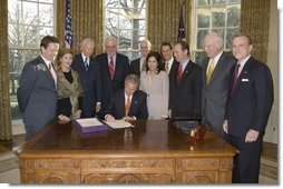 Accompanied by Laura Bush and legislators, President George W. Bush signs H.R. 3402, The Violence Against Women and Department of Justice Reauthorization Act of 2005, during a ceremony in the Oval Office Thursday, Jan. 5, 2005. The bill is a comprehensive package that reauthorizes Department of Justice programs to combat domestic violence, dating violence, sexual assault, and stalking. White House photo by Paul Morse