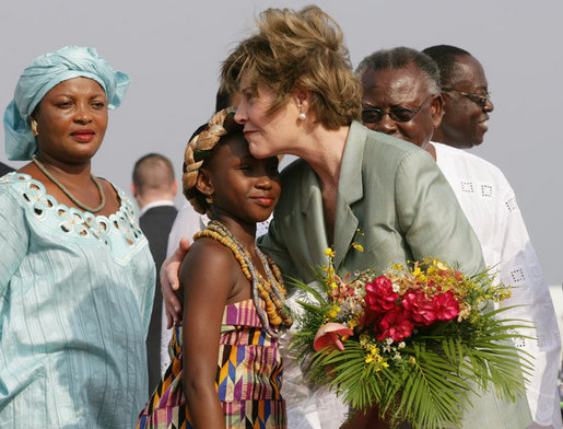 Mrs. Laura Bush embraces 10-year-old Aisha Garuba Sunday, Jan. 15, 2006, after she presented Mrs. Bush with flowers upon her arrival at Kotoka International Airport in Accra, Ghana. White House photo by Shealah Craighead