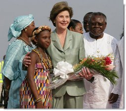 Mrs. Laura Bush stands with 10-year-old Aisha Garuba Sunday, Jan. 15, 2006, after she presented Mrs. Bush with flowers upon her arrival at Kotoka International Airport in Accra, Ghana. White House photo by Shealah Craighead