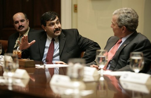 President George W. Bush listens to Mr. Raid Mohammad Wednesday, Jan. 18, 2006, during a visit at the White House with victims of Saddam Hussein. Mr. Mohammad's father was a journalist in Iraq who imprisoned and eventually killed by Saddam's men. White House photo by Eric Draper