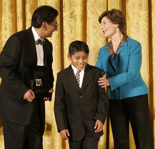 Laura Bush congratulates Jose Fernando Salas, left, and Carlos Gabriel Pascual from the Art and Children Program of Veracruz, Mexico, at their award presentation Wednesday, Jan. 25, 2006 in the East Room of the White House, during the President's Committee on the Arts and the Humanities 2006 Coming Up Taller Awards ceremony. White House photo by Shealah Craighead