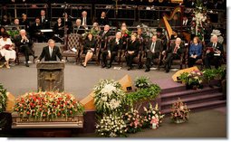 President George W. Bush addresses guests at the homegoing celebration for Coretta Scott King, Tuesday, Feb. 7, 2006 at the New Birth Missionary Church in Atlanta, Ga. In the background-right are Mrs. Laura Bush, former President Bill Clinton, U.S. Sen. Hillary Clinton, former President George H. W. Bush, former President Jimmy Carter, Mrs. Roslyn Carter and U.S. Sen. Edward M. Kennedy.  White House photo by Eric Draper