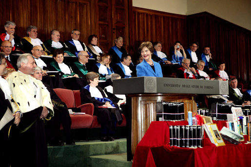 Laura Bush smiles at Enrico Artifoni, Library President, right, and a member of the Faculty Deans Saturday, Feb. 11, 2006, in Turin, Italy, while delivering remarks during a visit to the University of Turin. Mrs. Bush announced a donation, made possible by the U.S. Department of State, of more than 200 American books to the University of Turin American studies program. White House photo by Shealah Craighead