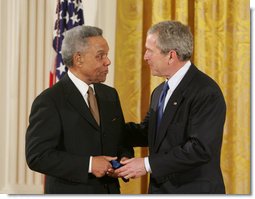 President George W. Bush congratulates Dr. Carl Anderson of Washington, upon receiving the President's Volunteer Service Award during a White House celebration of African American History Month. White House photo by Paul Morse