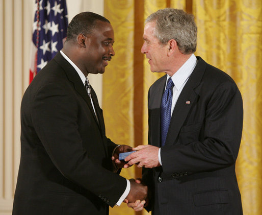 President George W. Bush congratulates Steve Ellis of Carrollton, Texas, upon receiving the President's Volunteer Service Award during a White House celebration of African American History Month. White House photo by Paul Morse