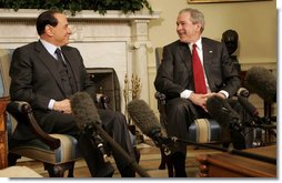 President George W. Bush smiles as he and Italian Prime Minister Silvio Berlusconi meet the media in the Oval Office Tuesday, Feb. 28, 2006. The President used the occasion to commend the Prime Minister for the stability he's brought to the Italian government and to applaud his country's recent success with the Olympic Games.  White House photo by Kimberlee Hewitt