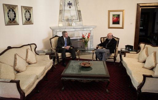 President George W. Bush and Afghan President Hamid Karzai talk Wednesday, March 1, 2006, in the Presidential Palace in Kabul. President and Mrs. Bush made the surprise five-hour stop in Afghanistan en route to India. White House photo by Eric Draper