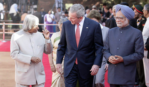 President George W. Bush listens to India's President A.P.J. Abdul Kalam as they walk the red carpet with Prime Minister Manmohan Singh during the arrival ceremony in New Delhi Thursday, March 2, 2006, welcoming the President and Mrs. Bush to India. White House photo by Eric Draper