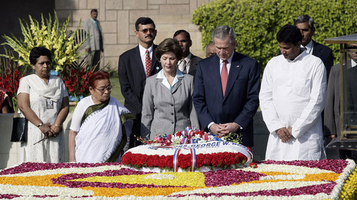 President George W. Bush and Laura Bush are joined by Rajnish Kumar, right, Secretary of the Rajghat Samadhi Committee, and Dr. Nirmila Deshpande, co-Chair of the Rajghat Gandhi Samadhi committee, for a moment of silence at the Mahatma Gandhi Memorial in Rajghat, India. White House photo by Eric Draper