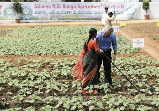 President George W. Bush greets a student in the middle of a field during his visit Friday, March 3, 2006, to the Acharya N.G. Ranga Agriculture University in Hyderabad, India. The President ended his visit to India Friday, flying to Pakistan for a day before heading back to Washington. White House photo by Eric Draper