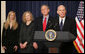 President George W. Bush stands with Victoria Lazear and her daughter Julie as Eddie Lazear offers remarks Monday, March 6, 2006, after being sworn in as Chairman of the Council of Economic Advisers. White House photo by Paul Morse