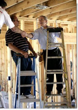 President George W. Bush shakes hands with people helping rebuild Jerry Akins family home, Wednesday, March 8, 2006 in Gautier, Miss., on the site where the Akins home was destroyed by Hurricane Katrina. White House photo by Eric Draper