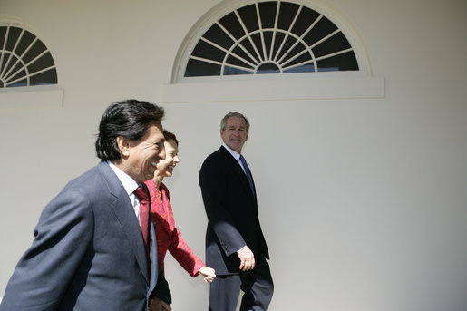 President George W. Bush walks with Peru's President Alejandro Toledo and his wife, Eliane Karp de Toledo, along the White House Colonnade, Friday, March 10, 2006, during their visit to the White House. White House photo by Eric Draper