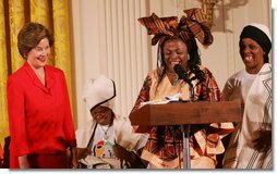 Mrs. Laura Bush reacts to remarks from Aunt Manyongo "Kunene" Mosima Tantoh, a member of the Mothers to Mothers-To-Be organization of South Africa, Monday, March 13, 2006 in the East Room at the White House. Mrs. Bush had earlier met with members of the group, who mentor and counsel mothers who come for prenatal care to clinics and find they are HIV-positive, on her visit to South Africa in July of 2005. Group member Gloria Ncanywa is seen at right.  White House photo by Shealah Craighead