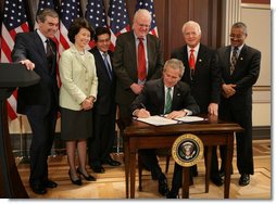 President George W. Bush signs the H.R. 32, the Stop Counterfeiting in Manufactured Goods Act, during ceremonies Thursday, March 16, 2006, in the Eisenhower Executive Office Building. Looking on are, from left: Secretary Carlos Gutierrez, Department of Commerce; Secretary Elaine Chao, Department of Labor; Attorney General Alberto Gonzales; U.S. Rep. Jim Sensenbrenner (R-Wis.); U.S. Rep.Joe Knollenberg (R-Mich.), and U.S. Rep. Bobby Scott (D-Va.). White House photo by Kimberlee Hewitt