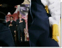 President George W. Bush and U.S. Attorney General Alberto Gonzales are framed by a military honor guard Monday, March 27, 2006, during the Naturalization Ceremony at the Daughters of the American Revolution Administration Building in Washington. President Bush, speaking to those who were swearing-in as new U.S. citizens, said that each generation of immigrants brings a renewal to our national character and adds vitality to our culture.  White House photo by Eric Draper