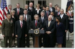 Flanked by members of the Cabinet, President George W. Bush delivers remarks to the media during a press conference Tuesday, March 28, 2006, in the Rose Garden of the White House. White House photo by Paul Morse