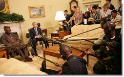 President George W. Bush speaks to the press as they gather Wednesday, March 29, 2006, in the Oval Office for a photo availability with President Olusegun Obasanjo of Nigeria. President Bush thanked President Obasanjo for his leadership and said, "Every time I meet with the President he brings a fresh perspective about the politics and the situation on the continent of Africa."  White House photo by Shealah Craighead