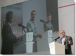 President George W. Bush addresses the media as Mexico's President Vicente Fox and Canadian Prime Minister Stephen Harper are seen on a large video screen listening during their joint news conference, Friday, March 31, 2006 at the Fiesta Americana Condesa Cancun Hotel in Cancun, Mexico. White House photo by Eric Draper