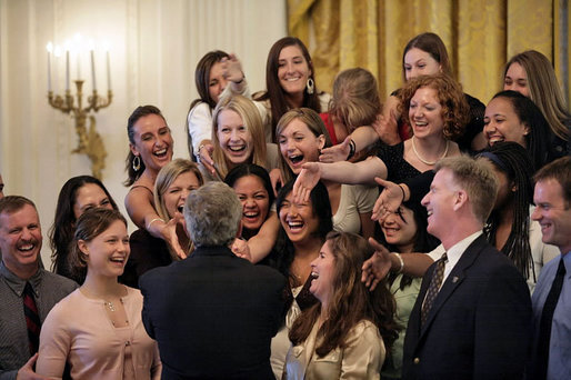 President George W. Bush reaches up to shake the hands with members of the University of Washington Women’s Volleyball Team Thursday, April 6, 2006, during a photo opportunity with the 2005 and 2006 NCAA Sports Champions. White House photo by Eric Draper