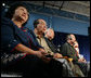 Audience members, some using headphones to hear a translation, listen to President George W. Bush talking to senior citizens at a Conversation on the Medicare Prescription Drug Benefit, Wednesday, April 12, 2006 at the Richard J. Ernst Community Center at Northern Virginia Community College in Annandale, Va. President Bush urged senior citizens to participate in the new Medicare drug benefit program to help reduce their drug costs. White House photo by Kimberlee Hewitt