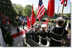 Flags are raised high as President George W. Bush and Mrs. Laura Bush make their way from the White House South Portico to participate in the South Lawn Arrival Ceremony for Chinese President Hu Jintao, Thursday, April 20, 2006. White House photo by David Bohrer