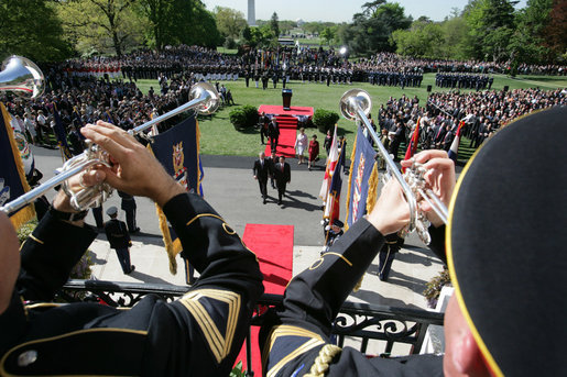 As trumpeters perform, President George W. Bush, President Hu Jintao, Laura Bush, and Hu’s wife, Liu Yongqing, walk into the White House after an arrival ceremony on the South Lawn, Thursday, April 20, 2006. White House photo by David Bohrer