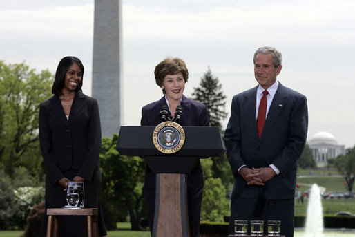 Mrs. Laura Bush addresses the audience Wednesday, April 26, 2006, as President Bush and Kim Oliver, the 2006 National Teacher of the Year, look on during a ceremony on the South Lawn honoring Ms. Oliver and the State Teachers of the Year. White House photo by Paul Morse