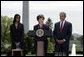 Mrs. Laura Bush addresses the audience Wednesday, April 26, 2006, as President Bush and Kim Oliver, the 2006 National Teacher of the Year, look on during a ceremony on the South Lawn honoring Ms. Oliver and the State Teachers of the Year. White House photo by Paul Morse