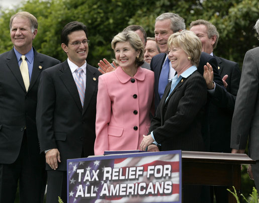 President George W. Bush puts his arms around U.S. Senator Kay Bailey Hutchison (R-Texas) and Ohio Congresswoman Deborah Pryce, right, after signing H.R. 4297, the Tax Relief Extension Reconciliation Act of 2005, during ceremonies Wednesday, May 17, 2006, on the South Lawn of the White House. White House photo by Eric Draper