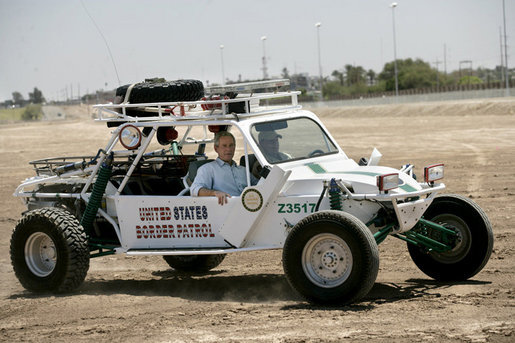 President George W. Bush rides in a U.S. Border Patrol dune buggy during a tour of the Yuma sector near the U.S. Mexico border in Yuma, Arizona, Thursday, May 18, 2006. White House photo by Eric Draper