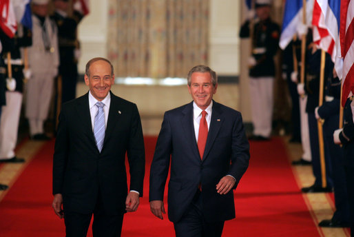 President George W. Bush walks through the Cross Hall with Prime Minister Ehud Olmert of Israel to a joint press conference in the East Room Tuesday, May 23, 2006. White House photo by Kimberlee Hewitt