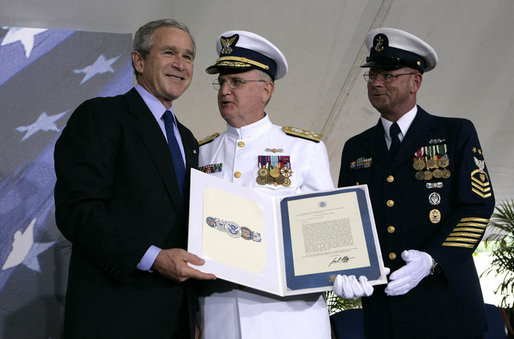 President George W. Bush presents Admiral Tom Collins, center, and Master Chief Petty Officer Frank Welch with the Presidential Unit Citation, Thursday, May 25, 2006 at Fort Lesley J. McNair in Washington, D.C., during the Change of Command Ceremony for the Commandant of the United States Coast Guard. White House photo by Eric Draper