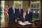 President George W. Bush is joined by Senator John Warner, R-Va, left, Senator Bill Frist, R-TN, center, and Congresswoman Virginia Foxx, R-NC, as he signs H.R. 1499, the Heroes Earned Retirement Opportunities Act, in the Oval Office Monday, May 29, 2006. White House photo by Paul Morse