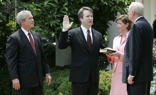 President George W. Bush looks on as Justice Anthony Kennedy swears in Brett Kavanaugh to the U.S. Court of Appeals for the District of Columbia during a ceremony Thursday, June 1, 2006, in the Rose Garden. Mrs. Ashley Kavanaugh holds the Holy Bible. White House photo by Eric Draper